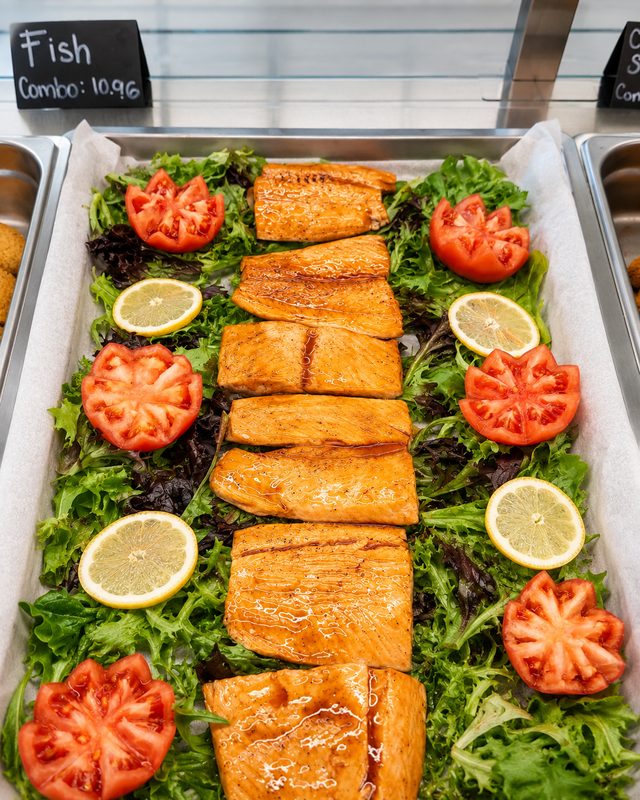 Grilled salmon on fresh greens with tomato and lemon